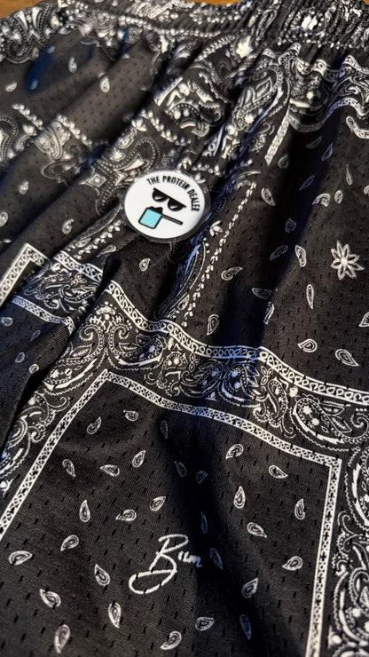 Acercamiento de los mesh shorts de la merch de CBum en blanco oy negro con patrón "paisley" o bandana