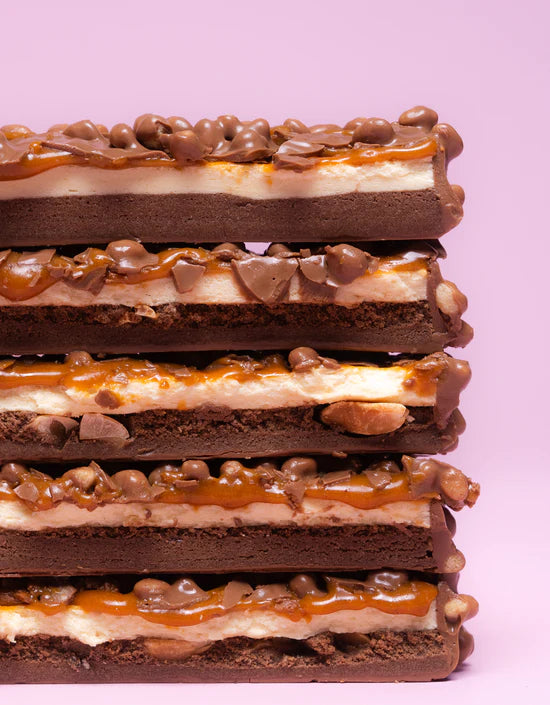 Acercamiento barrita Barebell sabor marshmallow peanut road mostrando detalles del relleno, cobertura y adiciones crocantes